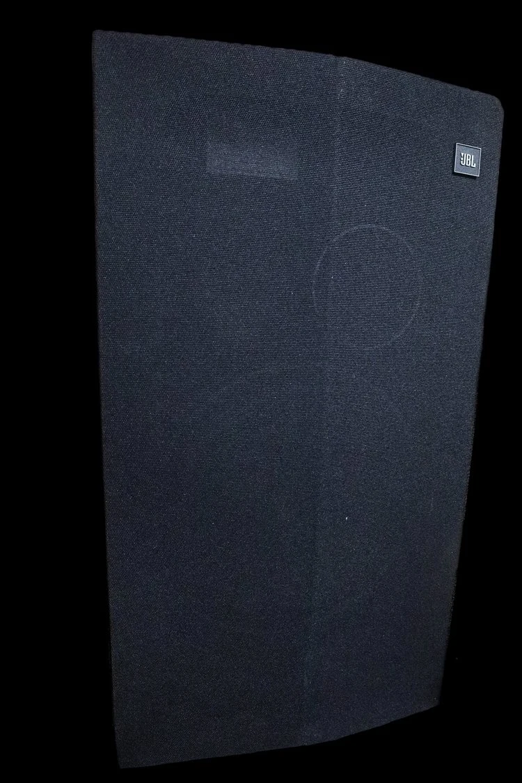 Close view of a black fabric speaker grille with a JBL badge.